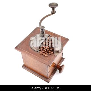 Alte hölzerne Kaffeemühle mit Kaffeebohnen drauf. Weißer Hintergrund. Stockfoto