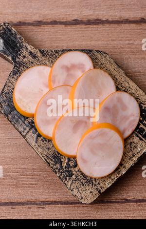 Gekochte Hähnchenwurst für Sandwiches und Antipasto zum Abendessen. Wurstscheiben als Lebensmittelhintergrund für Ihr Design Stockfoto