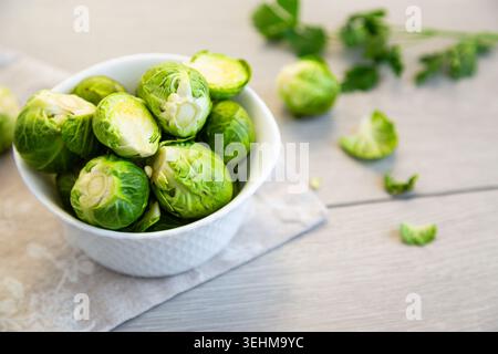 Frisches grünes Gemüse rosenkohl auf rustikalem Küchentisch. Stockfoto