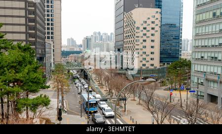 Weite Ansicht des Seoullo 7017 in Seoul, Südkorea, mit dem erhöhten Fußweg, modernen Hochhäusern, Stadtverkehr und Winterbäumen in einer Stadt Stockfoto