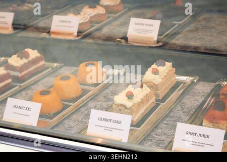 Nahaufnahme von verschiedenen Gebäck und Kuchen in einer Bäckerei Vitrine, mit Etiketten und überzogenen Desserts hinter Glas, mit süßen Leckereien und Gourmet-Patis Stockfoto