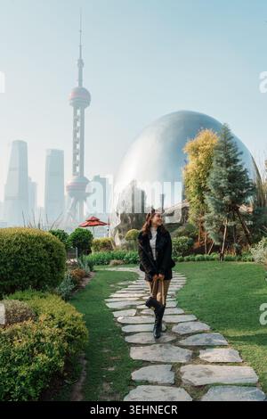 Stilvolle asiatische Frau genießt das North Bund Green Land mit Oriental Pearl Tower und Shanghai Skyline in China Stockfoto
