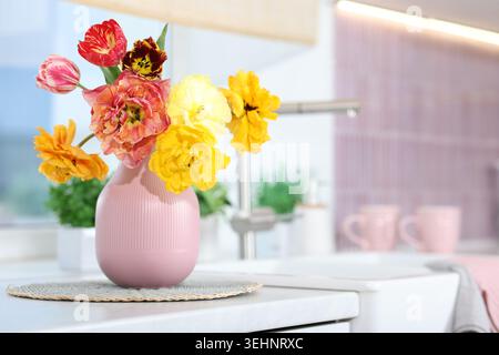 Schöne Tulpen in Vase auf der Arbeitsplatte in der Küche. Leerzeichen für Text Stockfoto
