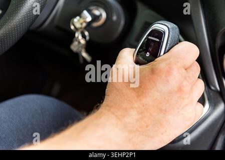 Nahaufnahme eines männlichen Hands am Schalthebel in einem modernen Fahrzeug Stockfoto