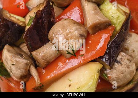 Essen, köstlicher Salat aus gegrilltem Gemüse Tomaten, Pilzen, Paprika, Auberginen, Zucchini, Salz, Gewürze und Kräuter auf einer Keramikplatte Stockfoto