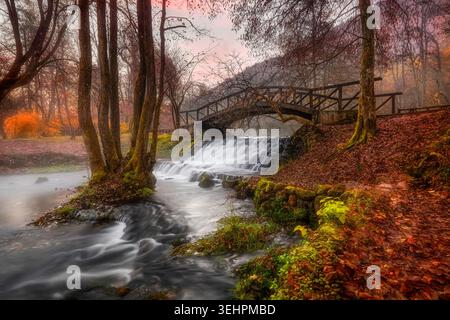 Holzbrücke und Herbstbach bei Vrelo Bosne in Bosnien und Herzegowina Stockfoto