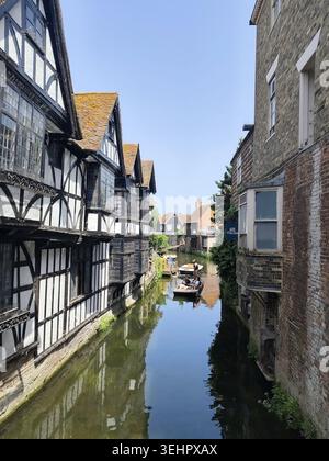 Besucher, die eine Bootstour auf dem Fluss Stour genießen. Das Fachwerkgebäude auf der linken Seite ist das berühmte Old Weavers House in Canterbury, Kent, Großbritannien Stockfoto