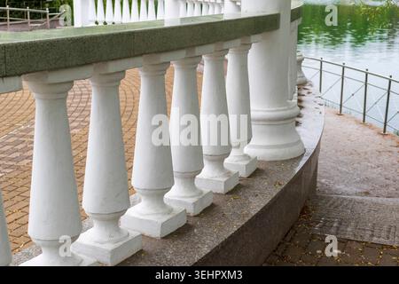 Geländer aus weißem Stein entlang einer Seepromenade in einem Park Stockfoto