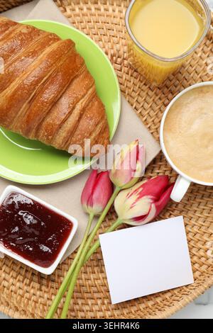 Tablett mit leckerem Frühstück und Tulpenblumen auf weißem Tisch, Nahaufnahme Stockfoto
