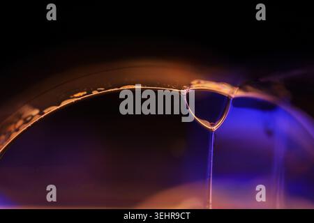 Abstrakte Makroaufnahme eines geometrischen Flüssigkeitsnetzwerks mit irisierenden Lichtreflexionen Stockfoto