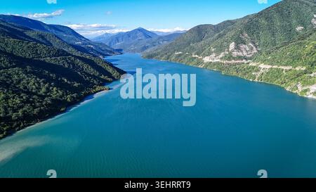 ZHINVALI, GEORGIEN - 14. AUGUST 2024: Eine Drohnenaufnahme fängt das malerische türkisfarbene Wasser des Zhinvali Reservoir ein, umgeben von üppigen grünen Bergen. Das riesige Wasserreservoir, das sich entlang der Georgian Military Highway befindet, ist ein beliebter Panoramastopp für Reisende und Ökotouristen. Stockfoto
