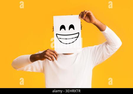 Afrikanische amerikanische Mann hält Papier mit Smiley Stockfoto