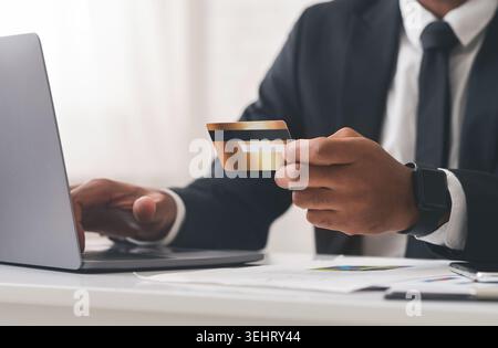 Foto von Geschäftsmann mit Laptop und Holding Kreditkarte 7/8 Stockfoto