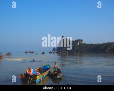 Fischerboote ruhen in ruhigen Morgengewässern einer Inselbucht aus. Stockfoto