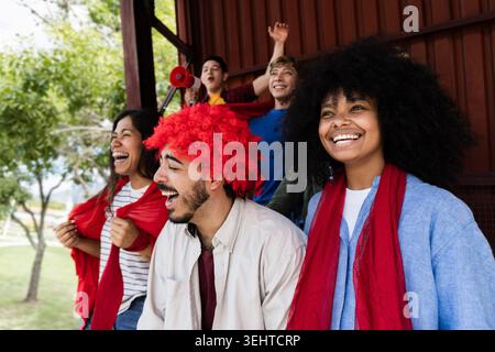 Fußballsportfans feiern den Sieg ihrer Lieblingsmannschaft im Stadion – die Leute jubeln ihrer Lieblingsmannschaft zu Stockfoto