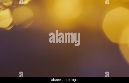 Sanftes goldenes und dunkles lila Licht verschmelzen zu einem glatten, traumhaften abstrakten Hintergrund. Stockfoto