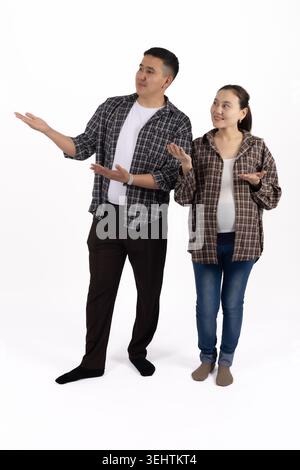 Junges, erwachsenes Paar, das steht und etwas mit Gesten diskutiert Stockfoto
