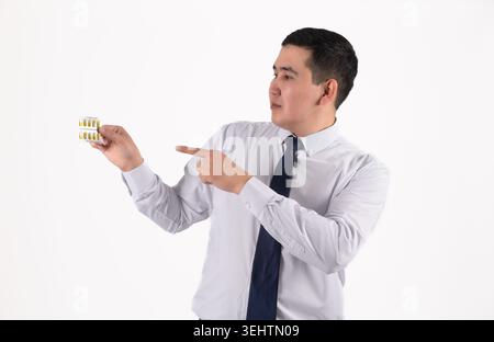 Junger, lächelnder asiatischer Geschäftsmann, der mit dem Finger auf den Kopierraum zeigt Stockfoto