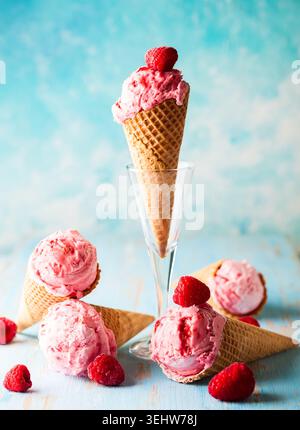 Eiscreme mit Himbeere in Waffel auf blauem Hintergrund Stockfoto
