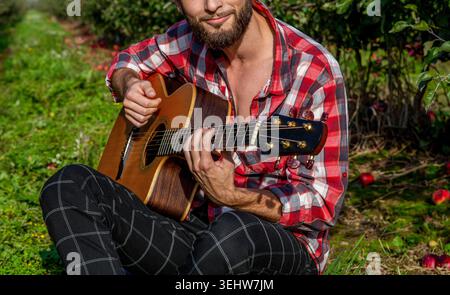 Gitarre. Akustikgitarren. Männlicher Musiker spielt Gitarre, Musikinstrument. Männerhände spielen Akustikgitarre Stockfoto