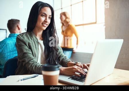 Frau, glücklich und tippt beim Start auf dem Notebook zur Überprüfung, Projektmanagement oder Einsicht in die Geschichte. Person, Autor und Zusammenarbeit mit dem Computer, Feedback Stockfoto