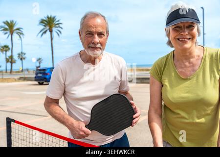 Seniorenpaar genießt aktiven Lebensstil beim Pickleball im Urlaub Stockfoto
