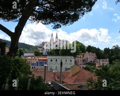 Ein malerischer Blick auf traditionelle weiße und pastellfarbene Gebäude in einer Stadt am Hügel, die auf eine Lage in Portugal hindeutet, eingerahmt von der si Stockfoto