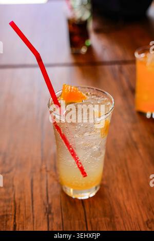 Glas frisches Eis Yusu Soda mit Orangenscheibe auf Holztisch. Stockfoto