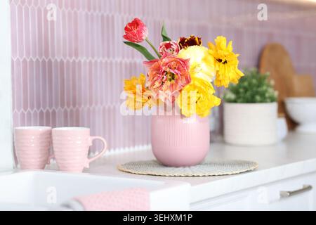 Schöne Tulpen in Vase auf der Arbeitsplatte in der Küche Stockfoto