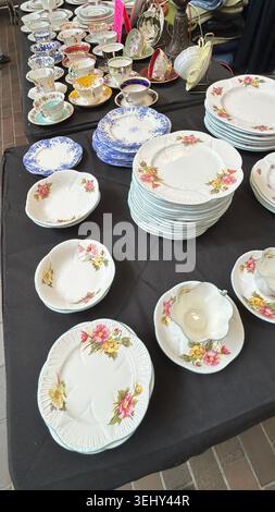Vintage Porzellan Porzellan Porzellan Geschirr Sets und Teetassen zum Verkauf auf einer schwarzen Tischdecke ausgestellt Stockfoto