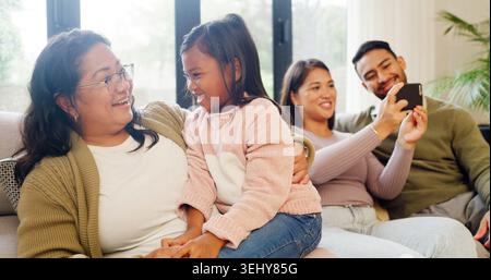 Glückliche Familie, die Beziehung und das Spielen mit dem Kind auf dem Sofa für Spaß in der Kindheit, Liebe oder Pflege zu Hause. Mom, Dad und Oma mit Lächeln, Kind oder Enkelin Stockfoto
