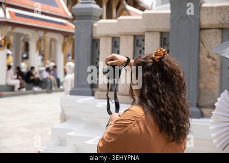 Weibliche Touristen, die Fotos mit Digitalkamera machen, Touristen erkunden Bangkok, während sie Fotos machen, Seitenprofil Stockfoto