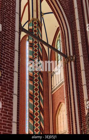 Bad Doberan, Deutschland - 19. Juli 2025: Blick auf das Innere des Doberaner Munster mit verzierten Ziegelsteinmauern, einer dekorativen gemusterten Säule und hoher Gote Stockfoto