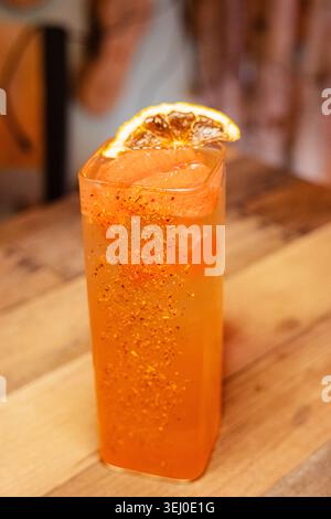 Ein erfrischender, farbenfroher Cocktail, garniert mit Orange Stockfoto