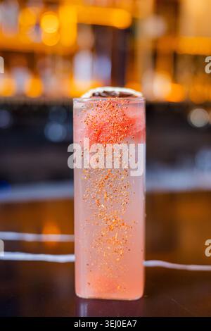 Ein erfrischender, farbenfroher Cocktail garniert mit Orangenschale und Eis Stockfoto