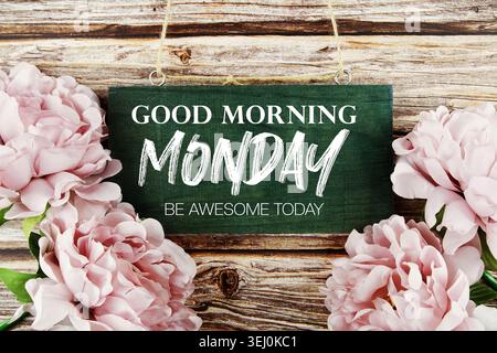 Guten Morgen Montag sei fantastisch heute Text geschrieben auf Holzdiele mit Blumendekoration auf hölzernem Hintergrund Stockfoto