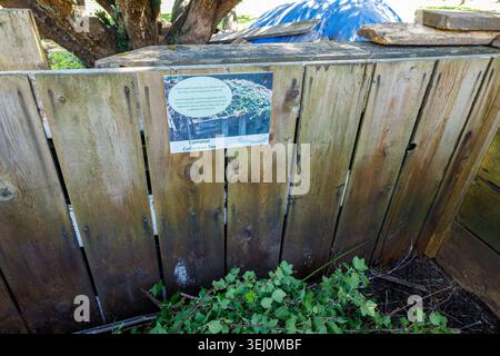 Vancouver, Kanada - 25. April 2026: Hölzerne gemeinschaftliche Kompost-Sammelbucht mit pädagogischem Schild, auf dem das hinzuzufügende Material erklärt wird, blaue Plane auf der Oberseite und Stockfoto