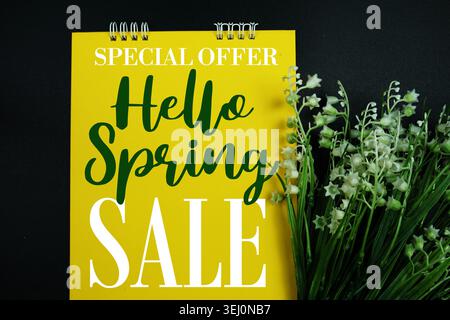 Hello Spring Sale Text mit Blumenstrauß auf schwarzem Hintergrund Stockfoto