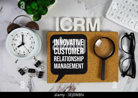 ICRM – innovatives Akronym für Customer Relationship Management mit Taschenrechner, Wecker und Lupe, Hintergrund Geschäftskonzept Stockfoto
