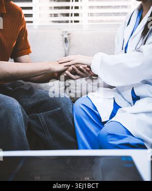 Ein Arzt hält Hände mit einem älteren Patienten. Stockfoto