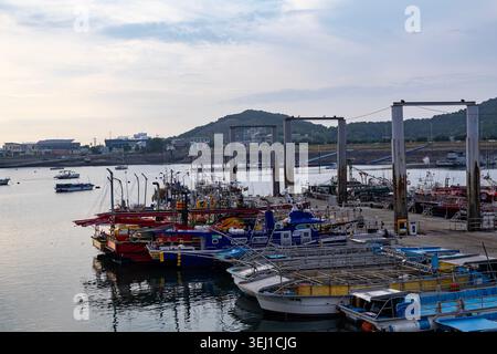 Jebudo, Südkorea - 05.25.2026 : Fischerboote und kleine Schiffe, die bei Abendlicht im friedlichen Küstenhafen vor Anker gestellt werden. Stockfoto