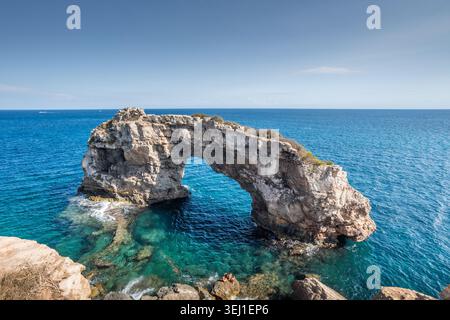 Der berühmte natürliche Felsbogen es Pontas erhebt sich aus kristallklarem türkisfarbenem und blauem Mittelmeer an der zerklüfteten Küste Mallorcas, Balearen Stockfoto