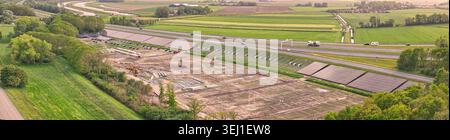 Luftaufnahme der Baustelle eines Solarparks entlang des Autobahndamms A7 in der Nähe des Seeschutzdeichs den Oever, Nordholland Stockfoto