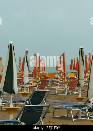 Leerer Strand mit geschlossenen Sonnenschirmen und Liegestühlen an der Adriaküste, Italien Stockfoto