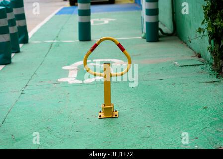 Gelbe Parkbarriere auf grünem Behindertenparkplatz Stockfoto