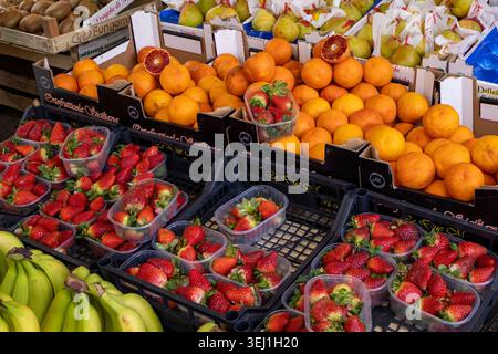 Bunte Auswahl an frischem Obst, darunter Erdbeeren, Orangen und Bananen auf dem Palermo Street Market, Sizilien. Gesunde Bio-Lebensmittel Stockfoto