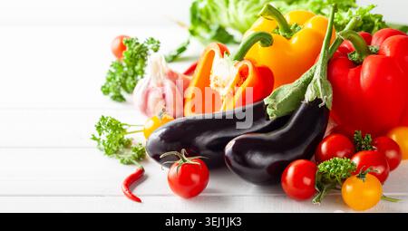 Verschiedene Arten von frischem Gemüse und Kräutern auf weißem hölzernem Hintergrund. Konzept der gesunden Ernährung, frisches Gemüse. Stockfoto