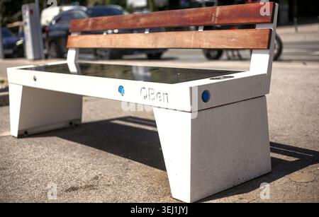 Eine innovative öffentliche intelligente Bank mit Solarpaneelen und Ladefunktionen für Geräte, die auf einem Straßenbelag in Opatija, Kroatien, installiert sind. Stockfoto