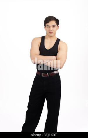 Junger Mann, der mit gekreuzten Armen im Atelier steht Stockfoto