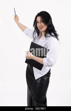 Eine junge Frau, die eine Mappe hält und auf einen Stift zeigt Stockfoto